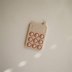 Zabawkowy telefon z przyciskami do zabawy dla niemowląt, w kolorze różowym, marki Mushie.