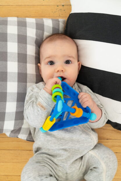 Dziecko bawi się gryzakiem - zabawką sensoryczna Wigloo, marki Mobi.