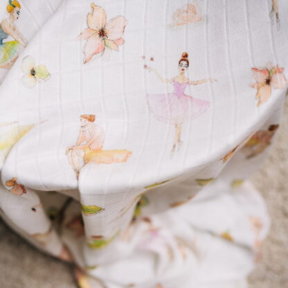 Zbliżenie na otulacz niemowlęcy ze wzorem tańczących baletnic, marki Layette.